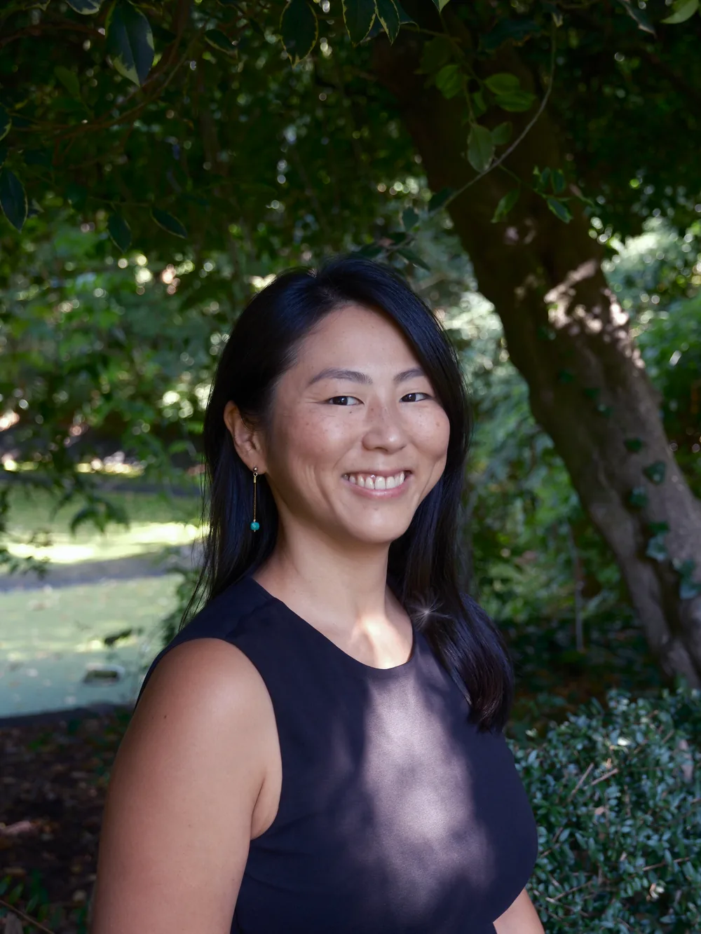 Akiko smiling, portrait under the trees of a park